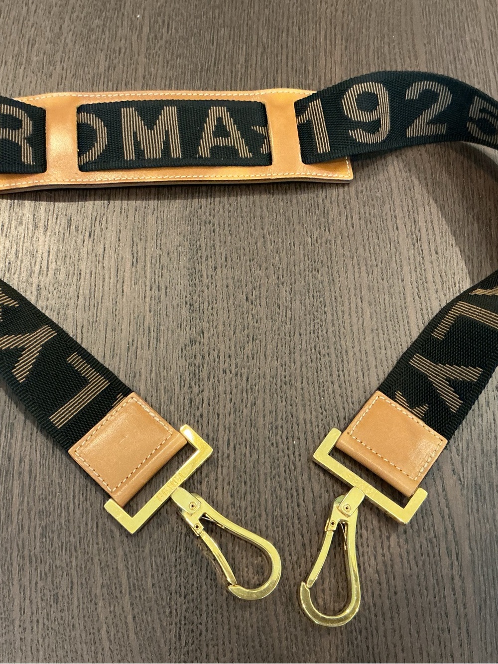 Fendi authentic Black and Tan Logo Webbing Unisex Bag Strap with Gold Hardware.